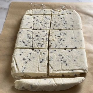 Un pezzo di fondente al cioccolato viene tagliato a quadratini