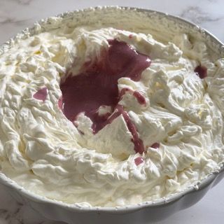 Una ciotola di panna montata con un liquido viola dentro