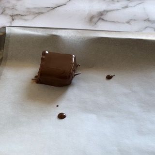 Un pezzo di cioccolato è appoggiato su un pezzo di carta oleata