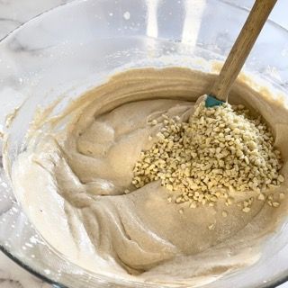 Una ciotola di pastella con noci e una spatola dentro