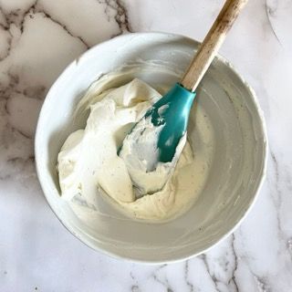 Una ciotola di panna montata con una spatola dentro