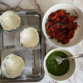 Un vassoio di cibo con una ciotola di pomodori e una ciotola di salsa verde