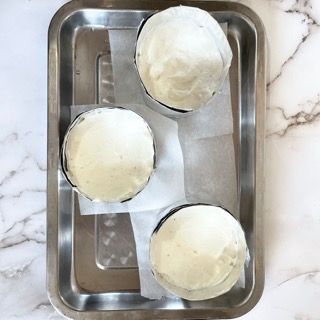 Tre cupcake avvolti in carta oleata su un vassoio di metallo