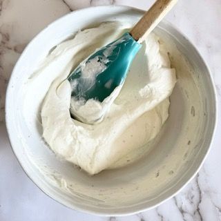 Una ciotola di panna montata con una spatola dentro