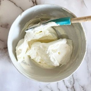 Una ciotola di panna montata con una spatola dentro