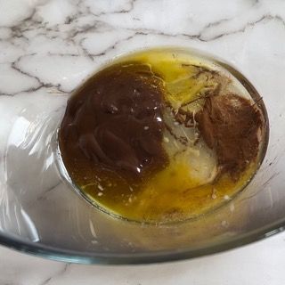Una ciotola di vetro piena di un liquido marrone e un liquido giallo