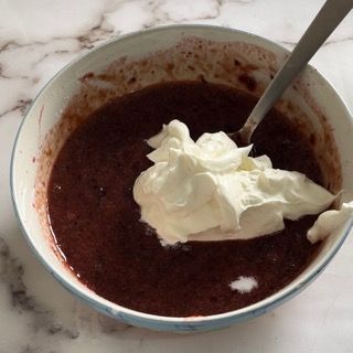 Una ciotola di zuppa con panna montata e un cucchiaio dentro