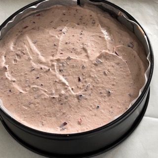 Una tortiera riempita di glassa rosa e noci