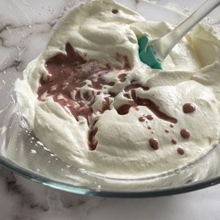 Una ciotola di panna montata con una spatola dentro