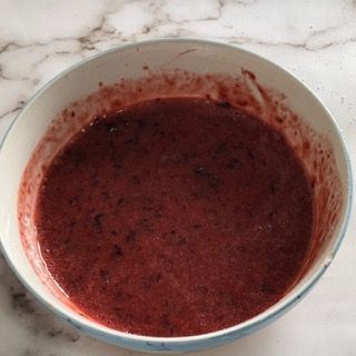 Una ciotola di liquido rosso è su un tavolo