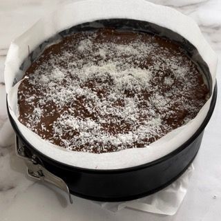 Una torta al cioccolato con cocco sopra in una padella