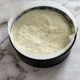 Una ciotola piena di polvere bianca è appoggiata su un tavolo.