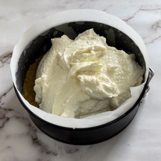 Una tortiera piena di panna montata su un tavolo