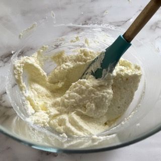 Una ciotola di panna montata con una spatola dentro.