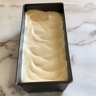 Una pagnotta di pane è appoggiata in una padella su un tavolo.