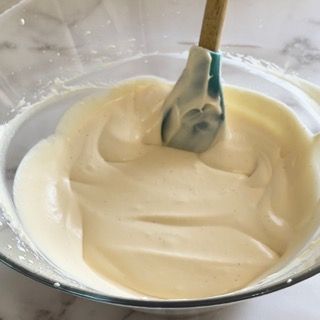 Una ciotola di panna montata con una spatola dentro.