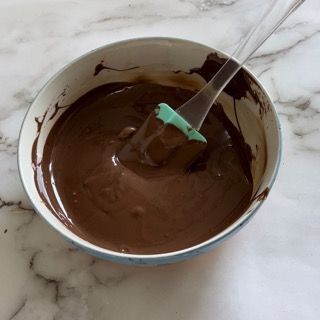Una ciotola di salsa al cioccolato con una spatola dentro
