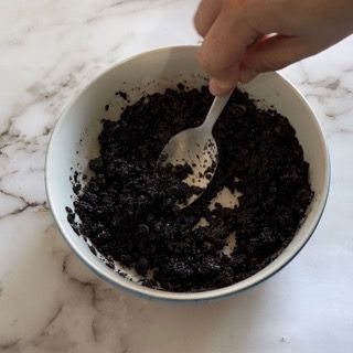 Una persona sta mescolando una ciotola di riso nero con un cucchiaio di plastica