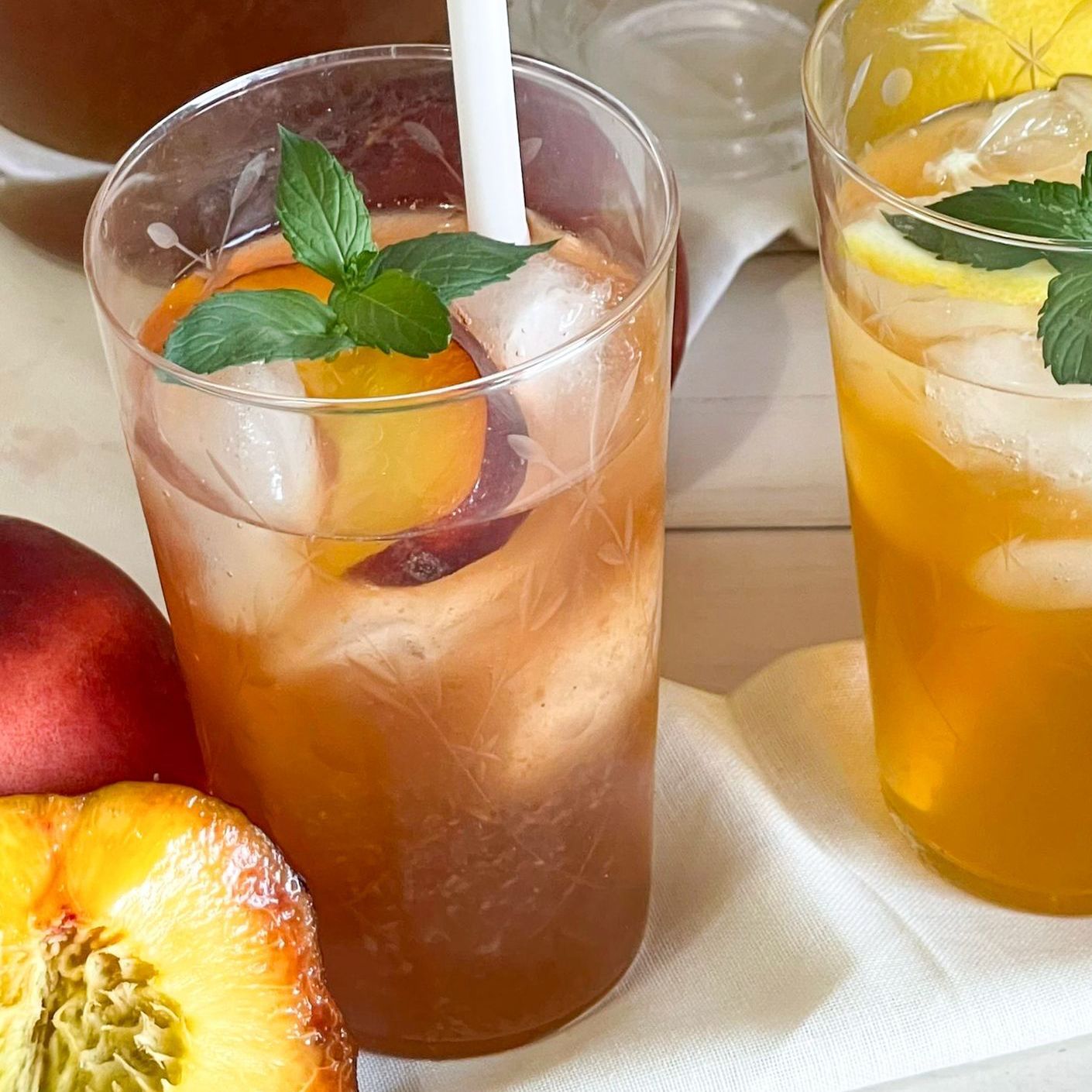 Due bicchieri di tè freddo con pesche e foglie di menta