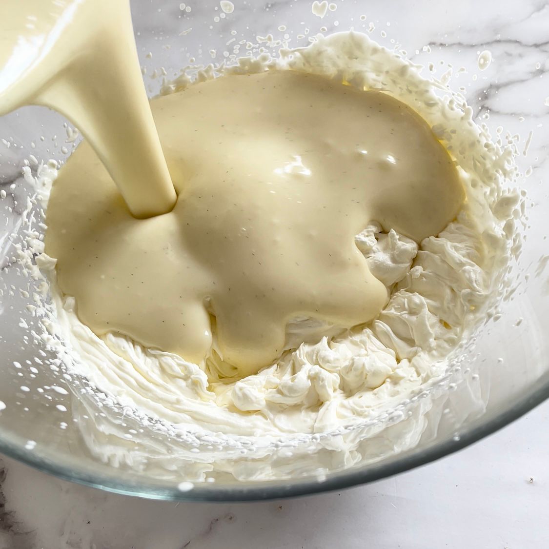 La panna montata viene versata in una ciotola di vetro.