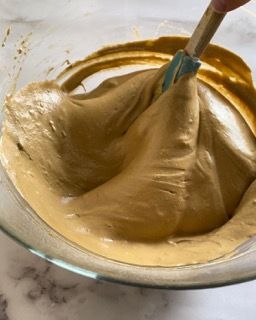 Una persona sta mescolando qualcosa in una ciotola con una spatola