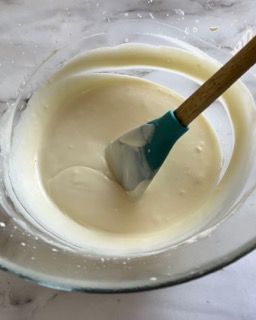 Una ciotola di liquido bianco con una spatola dentro.