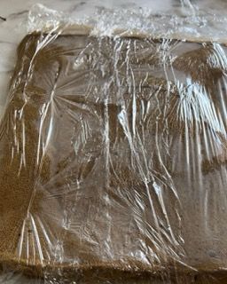 Un pezzo di pane è avvolto nella pellicola trasparente su un tavolo.