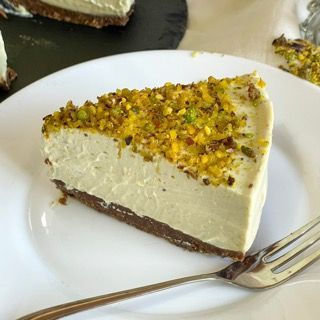 Un piatto bianco sormontato da una fetta di cheesecake e una forchetta