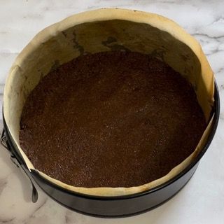 Una padella piena di impasto per brownie è appoggiata su un tavolo.