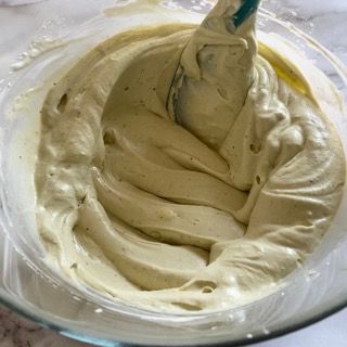 Una ciotola di glassa con una spatola dentro.