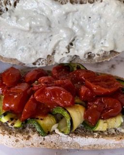 Un primo piano di un panino con pomodori e zucchine