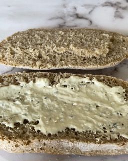 Due fette di pane imburrate su un tavolo.