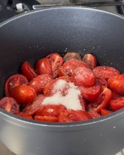 Una pentola piena di pomodori e sale su un fornello