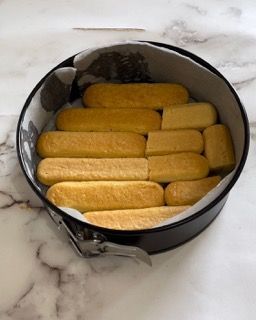 Una teglia piena di biscotti tiramisù su un tavolo