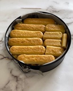 Una teglia piena di biscotti al tiramisù su un tavolo.