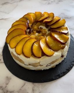 Una torta con sopra delle pesche tagliate a fette
