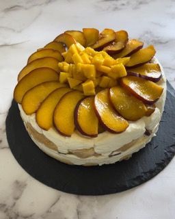 Una torta con sopra delle pesche tagliate a fette