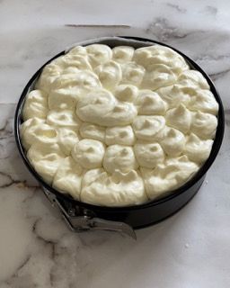 Una padella piena di panna montata è appoggiata su un tavolo.