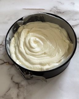 Una tortiera piena di panna montata su un tavolo.