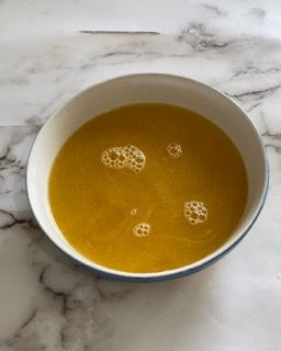 Una ciotola di liquido giallo con delle bollicine dentro