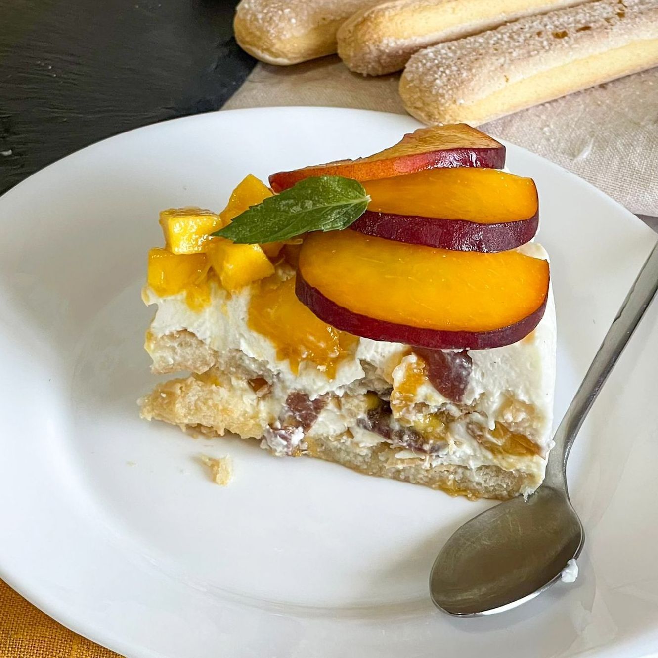 Un piatto bianco sormontato da una fetta di torta e un cucchiaio