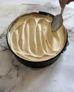 Una persona tiene un cucchiaio sopra una vaschetta di gelato