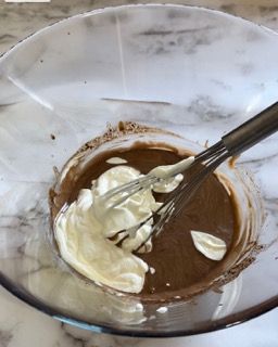 Una ciotola di cioccolato e panna montata con una frusta dentro
