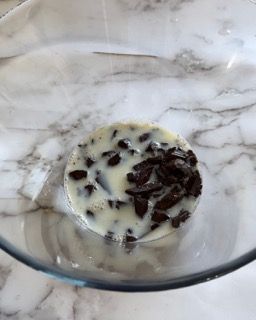 Una ciotola di latte e gocce di cioccolato su un tavolo.