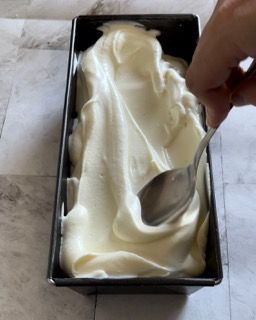 Una persona sta versando il gelato in una padella con un cucchiaio