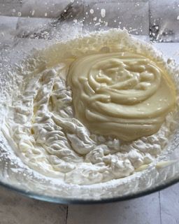 Una ciotola di vetro piena di panna montata e zucchero a velo