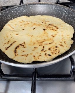 Una tortilla viene cotta in una padella sul fornello.