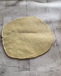 Un pezzo di pasta è appoggiato su una superficie di marmo.