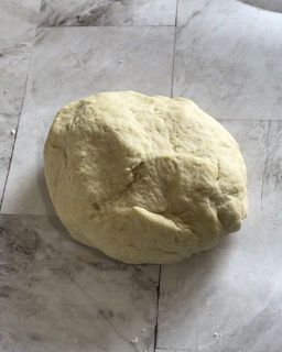 Una palla di pasta è appoggiata su un pezzo di carta oleata.