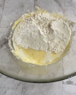 Una ciotola di vetro piena di farina e liquido su un tavolo.